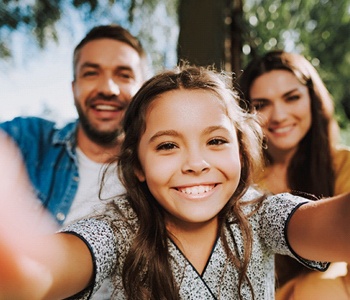 child taking a selfie with their parents