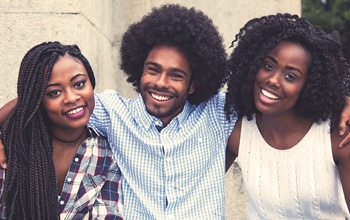 Three friends hugging and smiling