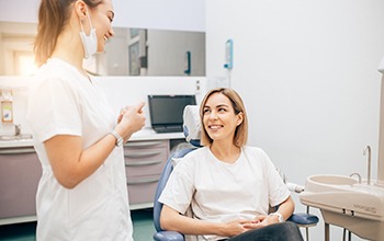 Patient and dentist smiling at each other during appointment