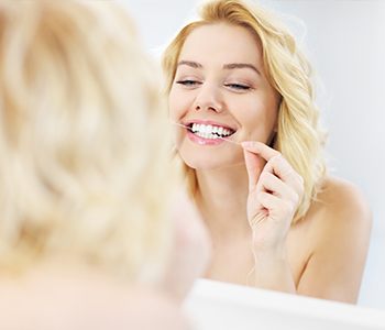 Young woman flossing her teeth