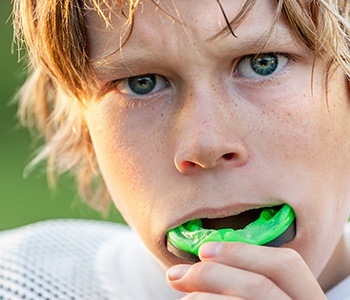 Teen boy placing mouthguard