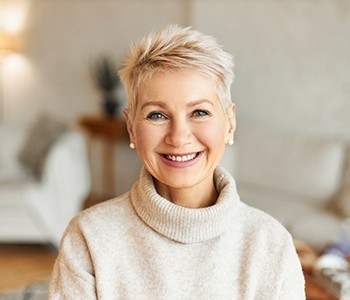 An older woman smiling because her porcelain veneers are covering her imperfections 