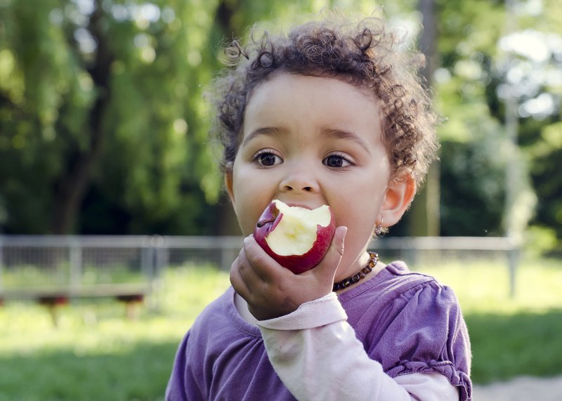 young child eating an apple